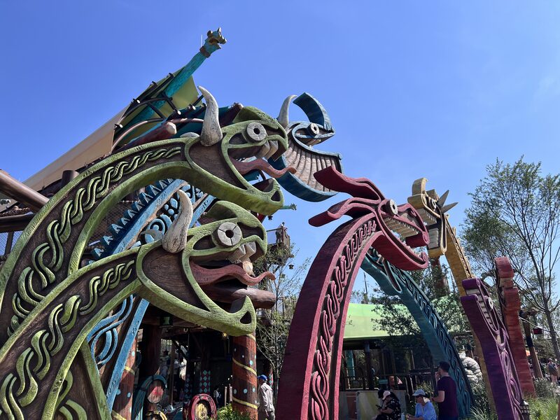 How to Train Your Dragon village entrance at Epic Universe: colorful Norse dragon arches and weathered wood
