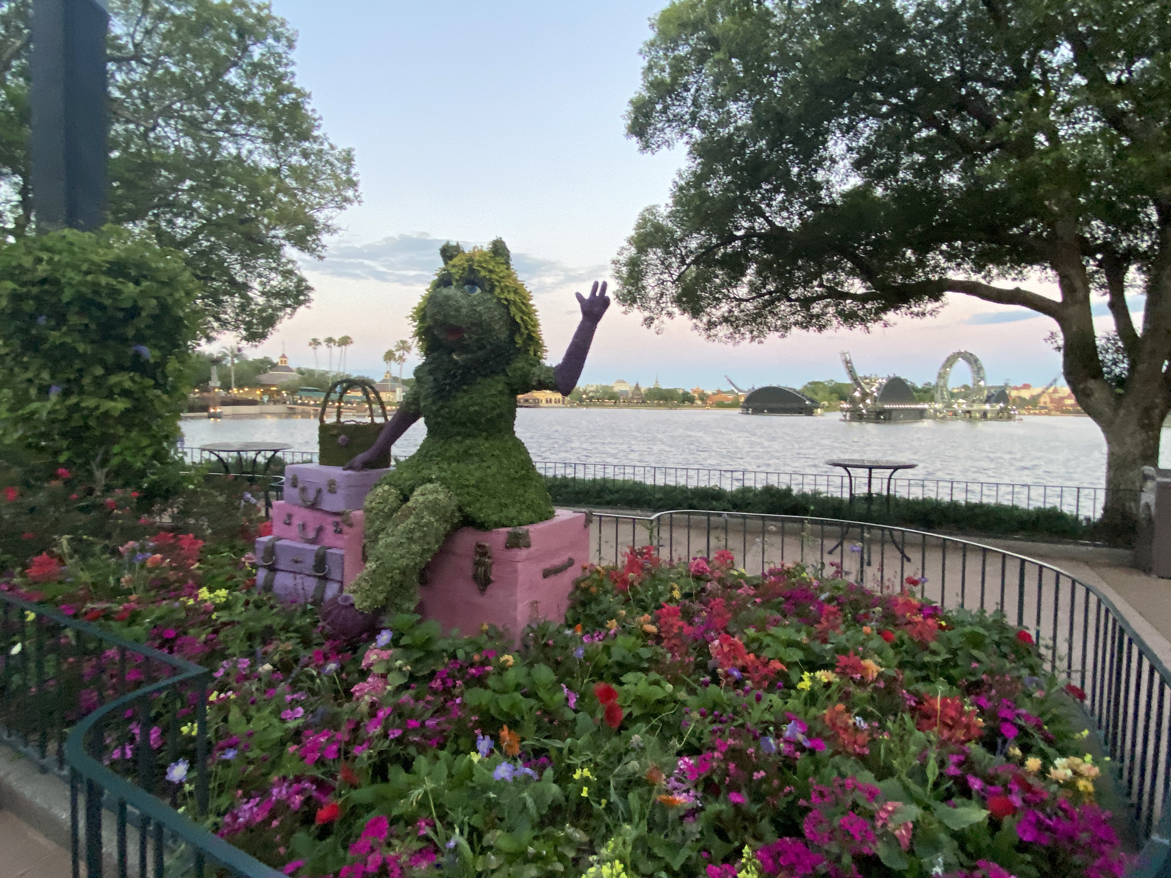 Miss Piggy topiary at EPCOT Flower and Garden Festival with World Showcase lagoon and festival structures in the background.